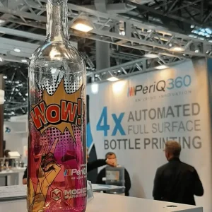 Clear glass bottle printed with Peri@360 on a Modico Graphic Systems trade fair stand
