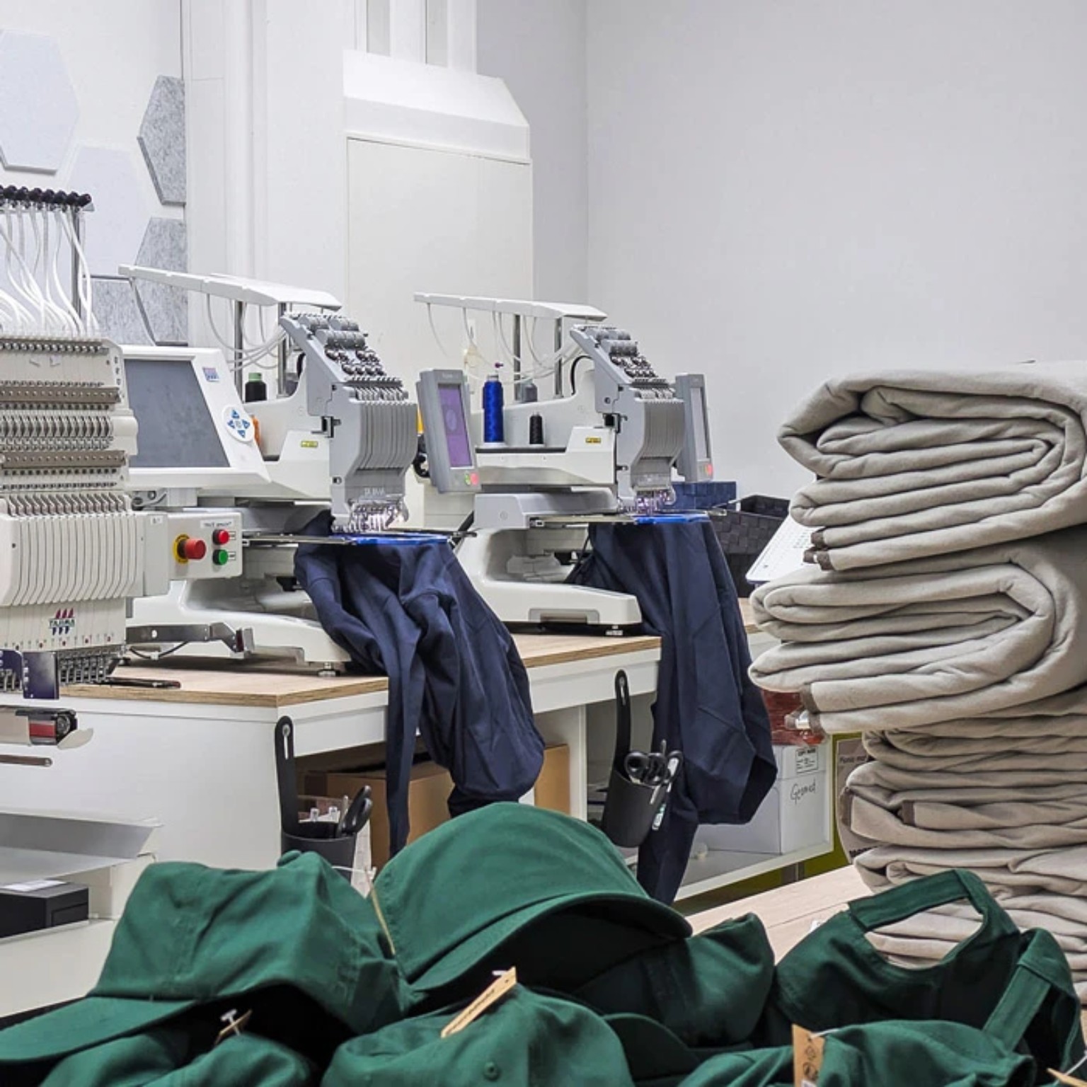 Tajima Stickmaschine mit Baseball Caps und großen Stoffballen bei Lamasuli Schweinfurt