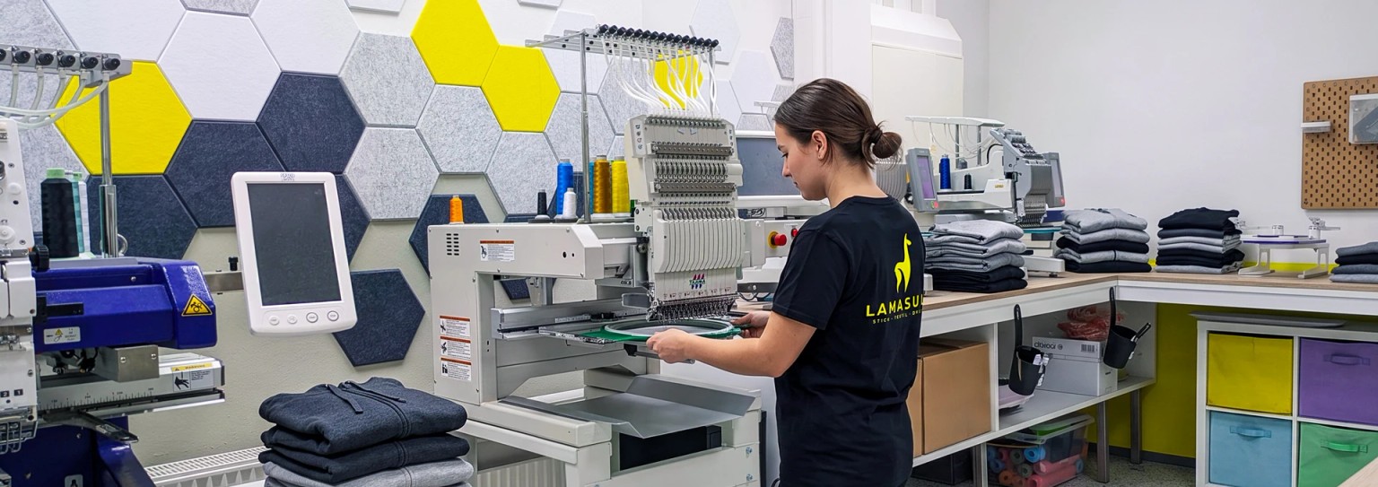 Eine Mitarbeiterin von Lamasuli in Schweinfurt an der Stickmaschine TMEZ von Tajima